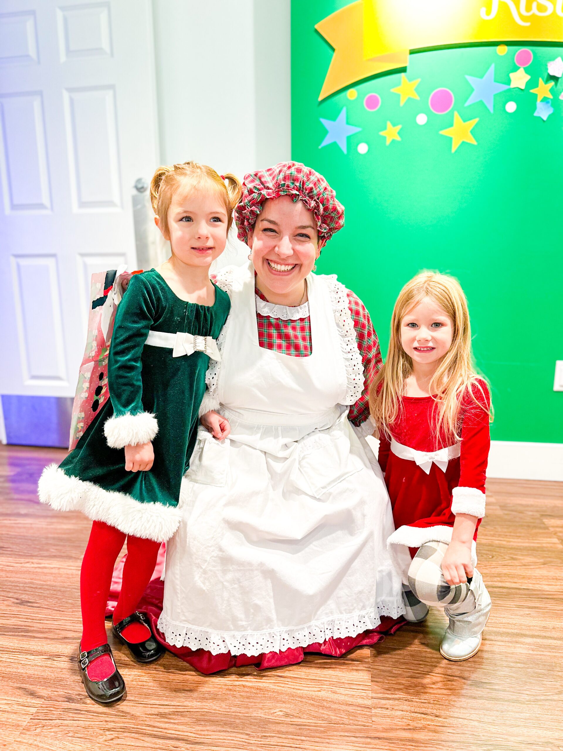 Mrs. Claus poses for a photo with kids in Back Stage Magic